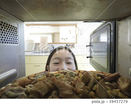 電子レンジでピザをあたためる様子 39457279
