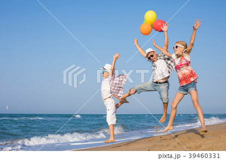 Father and son and daughter playing on the beach at the day time 39460331