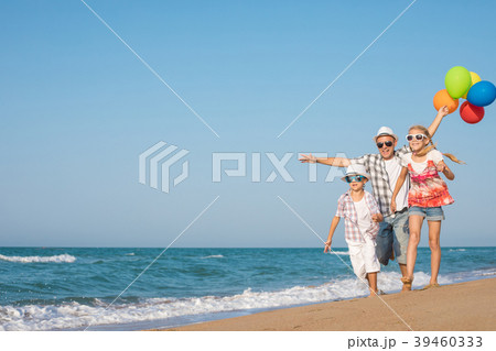 Father and son and daughter playing on the beach at the day time 39460333