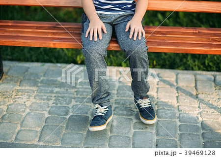 A little boy in a striped T-shirt is sitting on 39469128