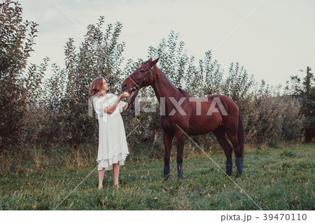 A woman feeds a horse 39470110
