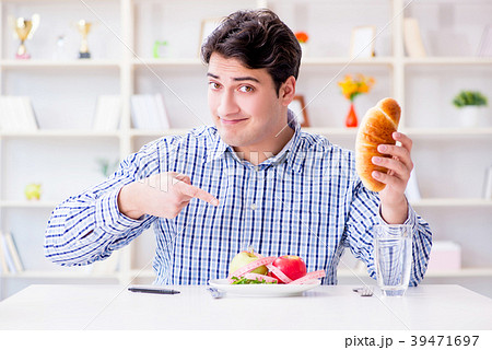 Man having dilemma between healthy food and bread 39471697