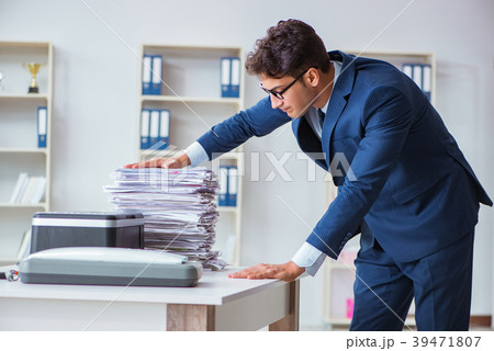 Businessman making copies in copying machine 39471807