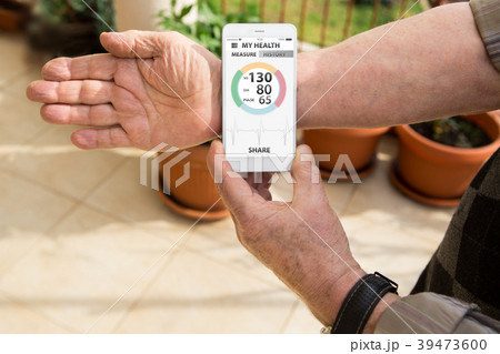 An elderly man measures blood pressure  39473600