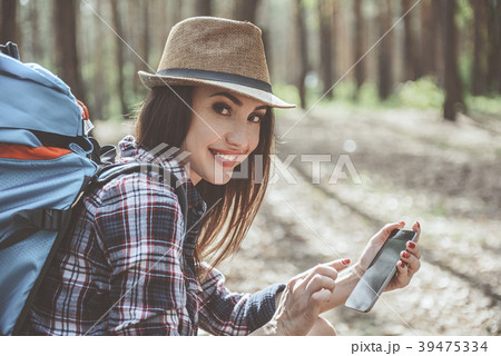 Optimistic girl is holding smartphone Optimistic girl is holding smartphone 39475334