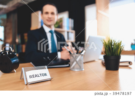 Realtor sitting at desk in office. Realtor sitting at desk in office. 39478197