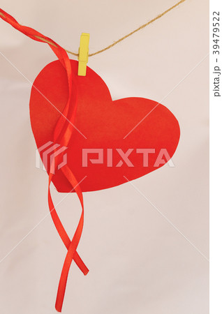 Red paper heart shape hanging on cloth line 39479522