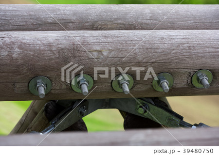 Wooden beams connected by metal screw and nut 39480750