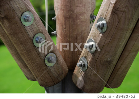 Wooden beams connected by metal screw and nut 39480752