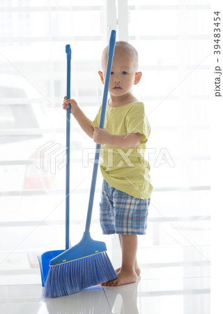 Young child sweeping floor 39483454
