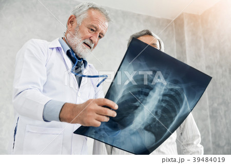 Doctor and patient are examining x-ray film. Doctor and patient are examining x-ray film. 39484019