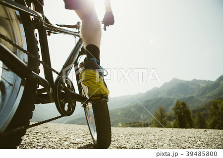Toned photo of man in sneakers on bicycle at road 39485800
