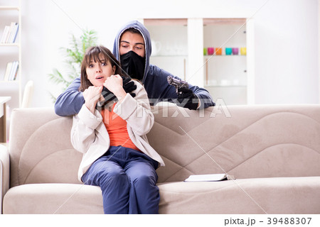 Armed man assaulting young woman at home 39488307
