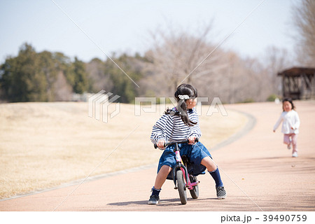 自転車で遊ぶ小学生の女の子の写真素材