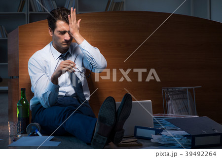 Stressed businessman working overtime in 39492264