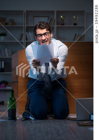 Stressed businessman working overtime in 39492286