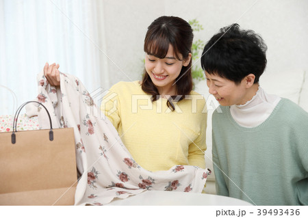 買ってきた洋服を母親に見せる娘 39493436
