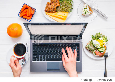 female working on laptop and having breakfast 39496356