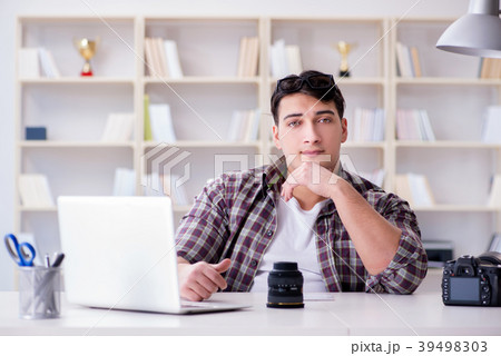 Young photographer sitting at the desk Young photographer sitting at the desk 39498303