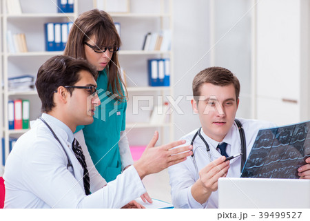 Three doctors discussing scan results of x-ray 39499527