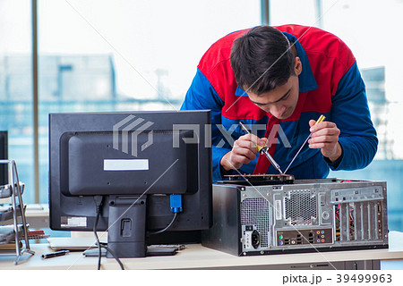 Computer technician repairing broken computer in 39499963