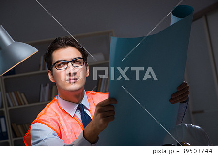 Construction architect working on drawings late at Construction architect working on drawings late at 39503744