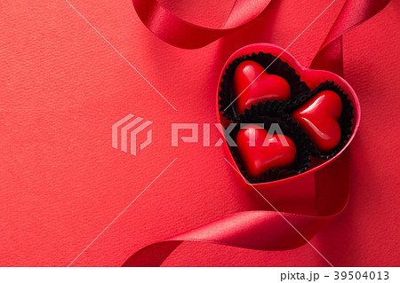 赤いリボンとハートのチョコレートのプレゼントのイメージ 赤いリボンとハートのチョコレートのプレゼントのイメージ 39504013