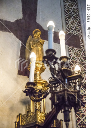 キャンドルスタンド越しにマリア像と十字架を見る 39504437