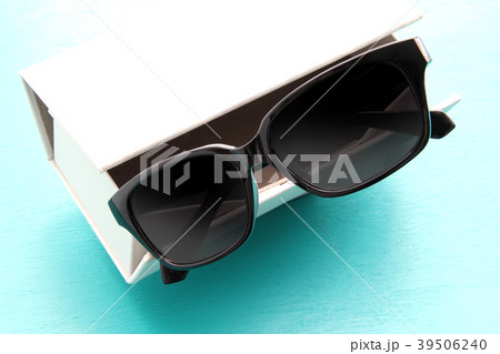 白い眼鏡ケースと黒縁のサングラス 39506240