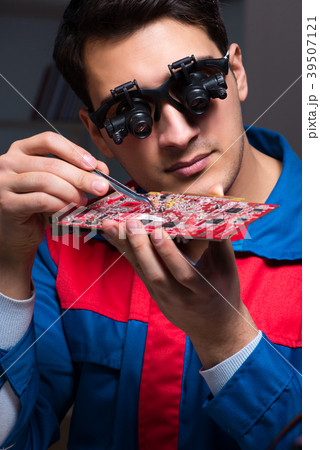 Computer specialist repairing PC late at night 39507121
