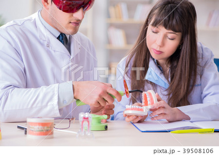 Doctor explaining to assistant how to use 39508106