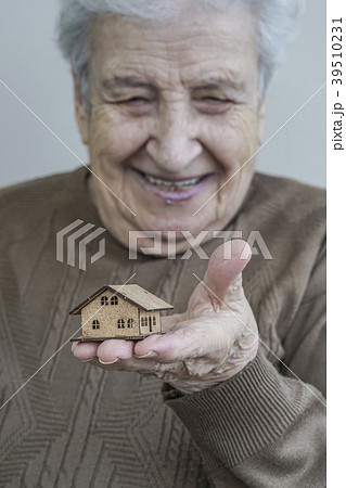 senior woman holding a small wooden house 39510231