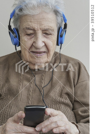 senior woman listening music with headphones senior woman listening music with headphones 39510512