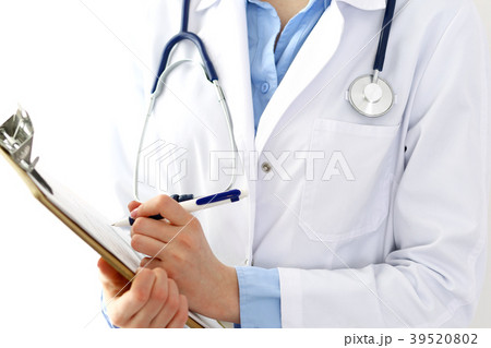 Female doctor filling up medical form on clipboard Female doctor filling up medical form on clipboard 39520802