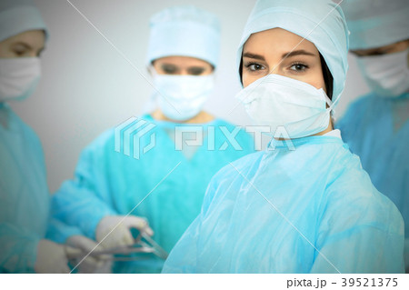 Medical team in masks performing operation. Focus 39521375