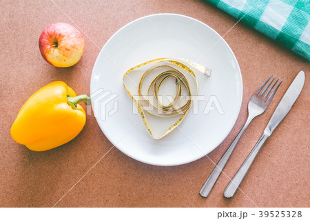 Empty plate, fork knife and tape measure on wooden Empty plate, fork knife and tape measure on wooden 39525328