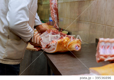 Cropped image of male butcher cutting raw Cropped image of male butcher cutting raw 39536896