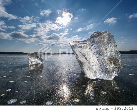 Transparent ice piece on the lake. Crystal ice Transparent ice piece on the lake. Crystal ice 39552612