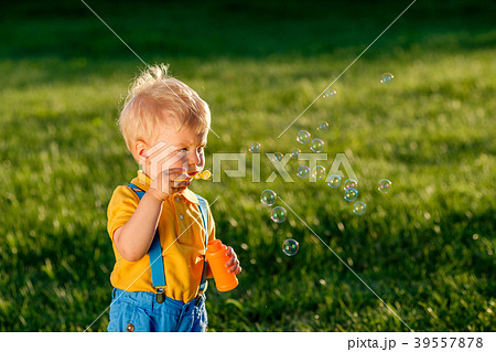 One year old baby boy blowing soap bubbles One year old baby boy blowing soap bubbles 39557878
