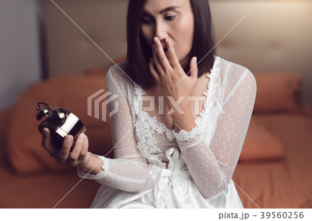 Woman in  shocked when wake up by alarm clock 39560256