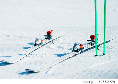 Skis and poles sticking out of the snow closeup 39560979