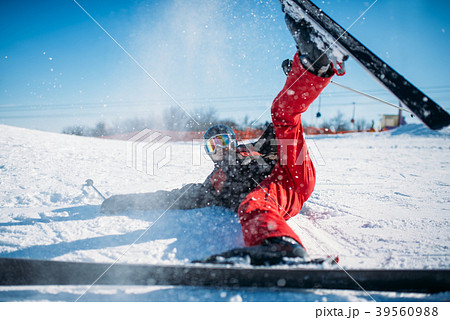 Skier in helmet and glasses lies on snowy mountain 39560988