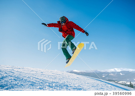 Snowboarder makes a jump on speed slope 39560996