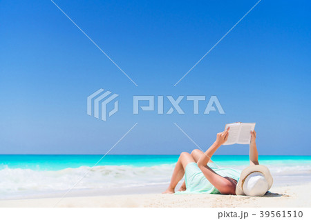 Young woman reading book during tropical white Young woman reading book during tropical white 39561510