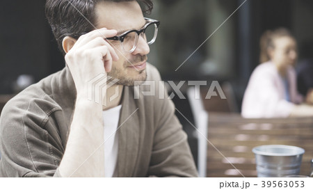 A man in eyeglasses smiling listening at cafe A man in eyeglasses smiling listening at cafe 39563053
