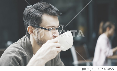 A closeup of man drinking coffee at cafe outdoors 39563055