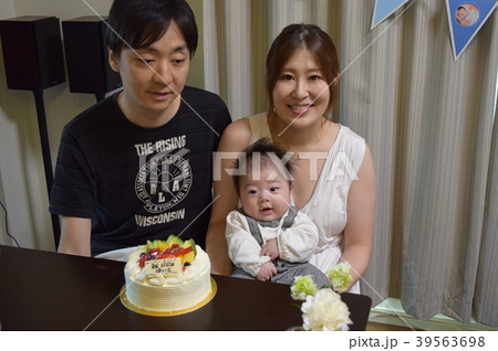生後100日の赤ちゃんを祝うファミリーとケーキの写真素材