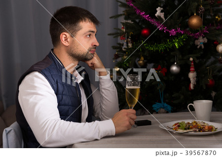 Young man celebrating New Year, having dinner, watching tv 39567870
