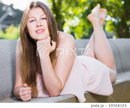 Elegant female is posing on bench in her free time Elegant female is posing on bench in her free time 39568103
