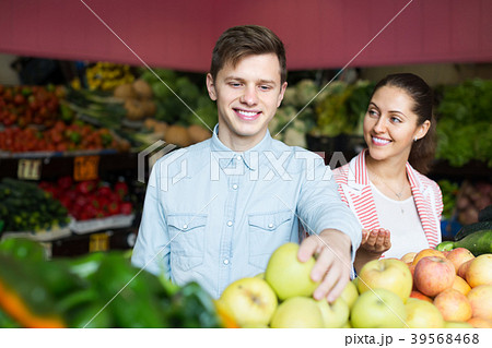 Couple choosing veggies and fruits . Couple choosing veggies and fruits . 39568468